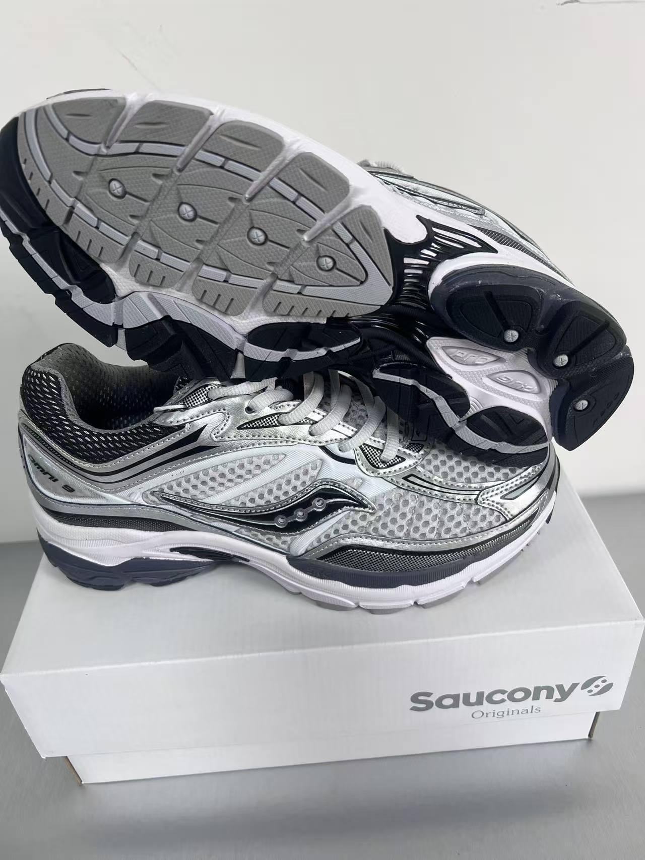 Saucony – Basket running rétro argent et noir à l’esthétique technique